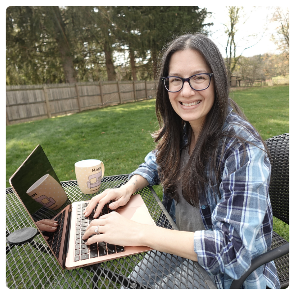 Developmental editor Rachel Clair working on a laptop outside on a spring day