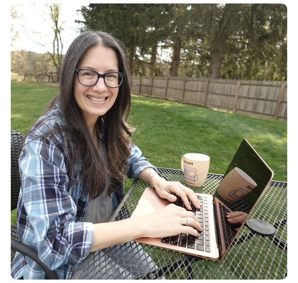Cozy mystery developmental editor Rachel Clair on a laptop outside
